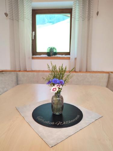a vase with flowers sitting on a table at Haus Enzian in Mittersill