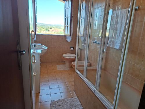a bathroom with a shower and a toilet and a window at Sitio dos Machados in Póvoa de Lanhoso