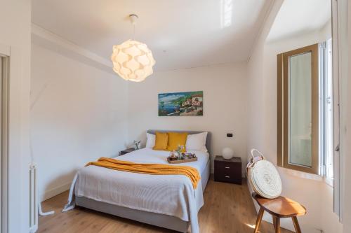 ein Schlafzimmer mit einem Bett und einer Pendelleuchte in der Unterkunft Family Nest on Lake Como by Rent All Como in Argegno