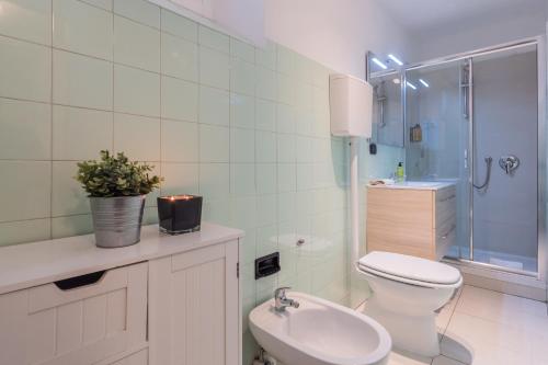 ein Badezimmer mit Toilette, Waschbecken und Dusche in der Unterkunft Family Nest on Lake Como by Rent All Como in Argegno