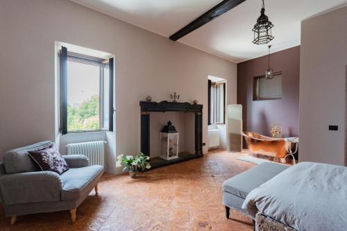 a bedroom with a fireplace and a bed and a chair at Castravalva Villa by Rent All Como in Mezzegra
