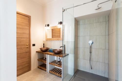 a bathroom with a glass shower and two sinks at Castravalva Villa by Rent All Como in Mezzegra