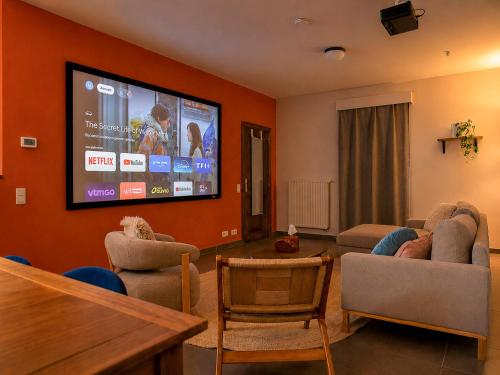 a living room with a flat screen tv on a wall at Les jardins du Quesnoy - 25min de Pairi Daiza in Blicquy