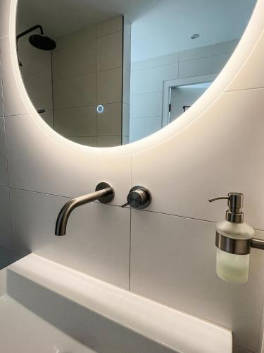 a bathroom with a sink and a mirror at Studio Margriet in Bergen