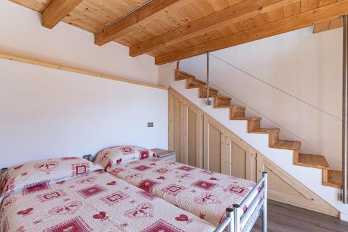 a bedroom with a bed and a staircase at Chalet Ca'Stanedi Valchiavenna in Voga
