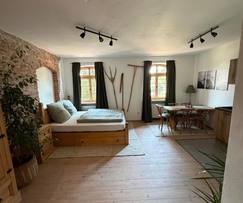 a living room with a bed and a table at falternhof apartment - geschichte trifft auf design in Höslwang