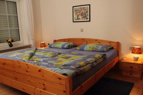 ein Schlafzimmer mit einem Holzbett mit zwei Kissen in der Unterkunft Ferienhof Lafrenz in Cuxhaven