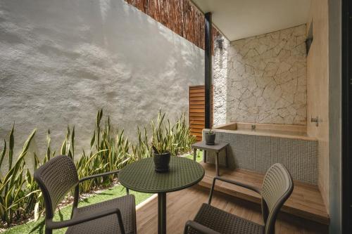 a patio with a table and chairs and a tub at Suites con piscina privada - Penca Suites Valladolid in Valladolid
