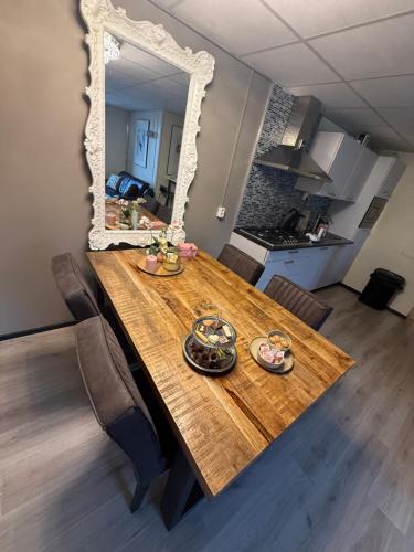 a dining room table with a mirror on the wall at The Quiet Escape in Strijen