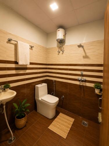 a bathroom with a toilet and a sink at Aanadam Resort in Jaipur