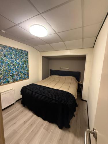 a bedroom with a bed and a painting on the wall at The Quiet Escape in Strijen