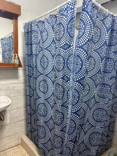 a bathroom with a shower with a blue and white shower curtain at Casa Azul by Silvia Sàmara in Nicoya