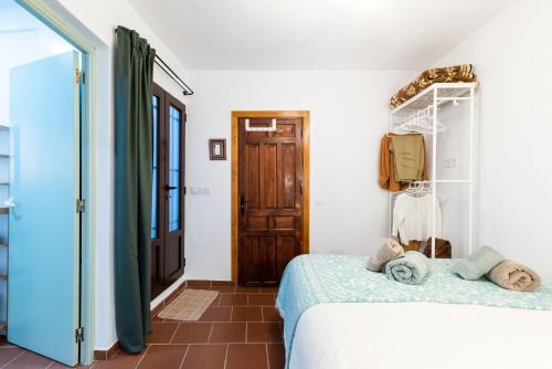 a bedroom with a bed in a room with a door at Patio Morisco - WIFI - free parking in Órgiva