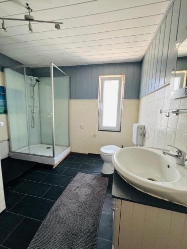 a bathroom with a tub and a toilet and a sink at CityStay House 42 in Bremerhaven