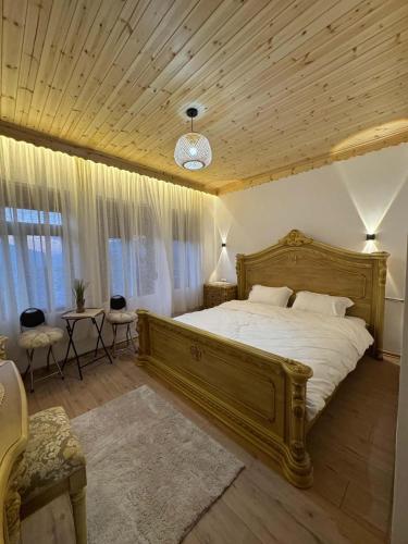a bedroom with a large bed and a wooden ceiling at Golden Guest House in Gjirokastër