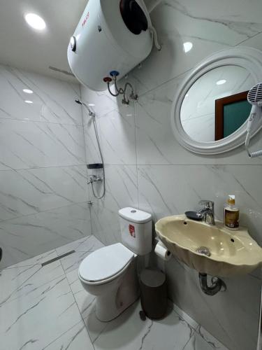 a white bathroom with a toilet and a sink at Golden Guest House in Gjirokastër