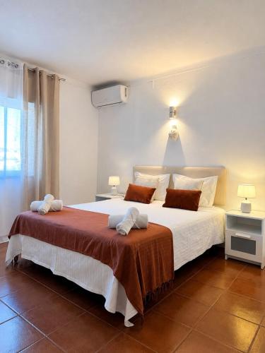 a bedroom with a large white bed with two pillows at Villa Cerro in Albufeira