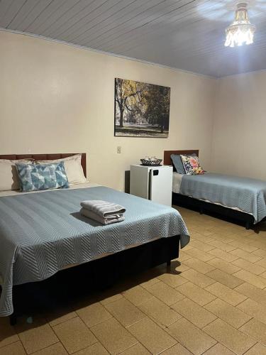 a bedroom with two beds and a table in it at Camping e Hostel Internacional in Foz do Iguaçu