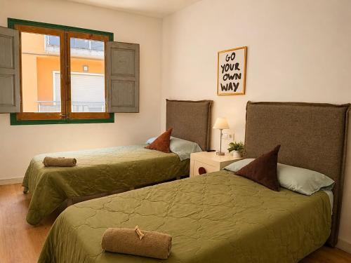 a bedroom with two beds and a window at CozyCatalonia - Exclusive Attic in Central Blanes in Blanes