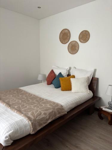 a bedroom with a bed with pillows on it at Casinha da Aurora in Pedorido