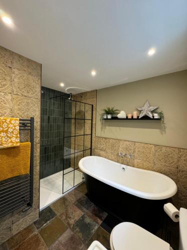 a bathroom with a bath tub and a shower at Vale View Cottages - The Stables in Prestatyn