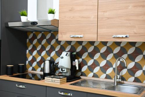 a kitchen with a sink and a coffee maker on a counter at Victry's Houses Chiaia in Naples