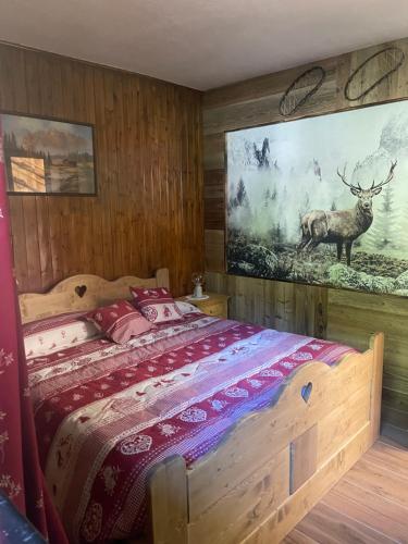 a bedroom with a bed with a deer painting on the wall at Le Flocon de neige in Valtournenche