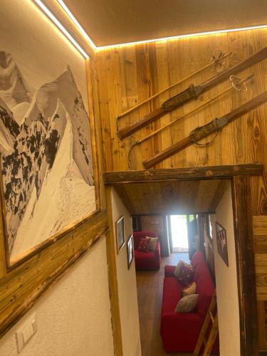 a room with a red couch and a picture of a mountain at Le Flocon de neige in Valtournenche