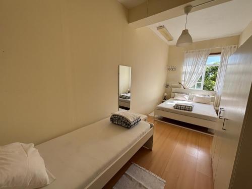 a small room with a bed and a mirror at Garden Hostel in Aradas