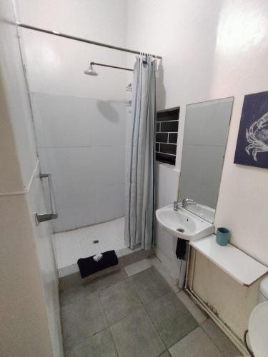 a white bathroom with a shower and a sink at Ocean Walk Starfish in Zinkwazi Beach