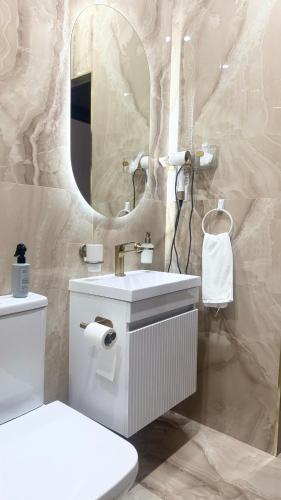 a bathroom with a toilet and a sink and a mirror at Malishka Eco Villas in Malishka