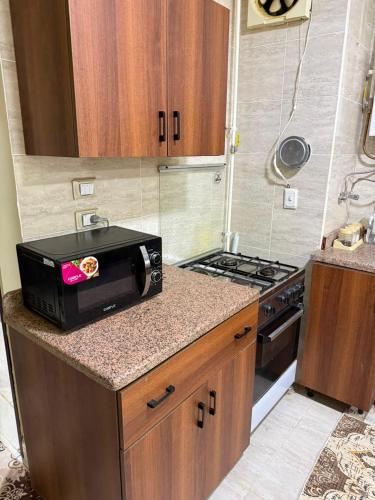 a small kitchen with a microwave and a stove at Fahd palm beach chalet in Ain Sokhna