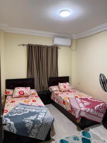 a bedroom with two beds and a window at Fahd palm beach chalet in Ain Sokhna