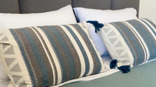a pile of pillows sitting on top of a bed at Βίλα Αντί Ονείρου-Διαμέρισμα Αριάδνη in Kriezá