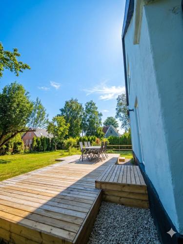 a wooden deck with a bench next to a building at The Green House Holiday Home in Tomelilla