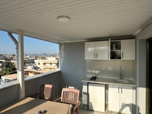 a kitchen with a table and chairs on a balcony at Yağmur Apart Otel in Didim