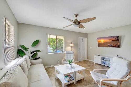 a living room with a white couch and a ceiling fan at 2 BR Home Close to The Beach in Lantana