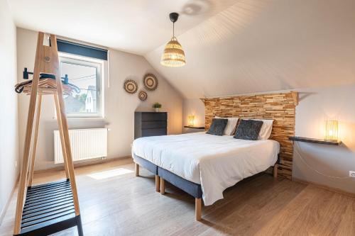 a bedroom with a bed and a brick wall at Gîte d'Anpa in Ohey