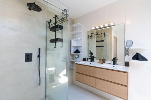 a bathroom with a sink and a shower with a mirror at Gîte d'Anpa in Ohey