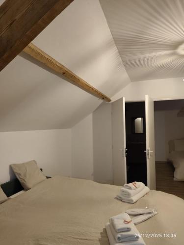 a bedroom with a bed with two towels on it at L'appartement à la ferme in Béthune