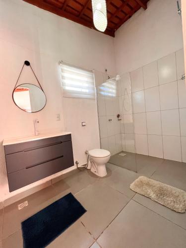 a bathroom with a toilet and a shower and a sink at Chácara buriti in Pirenópolis
