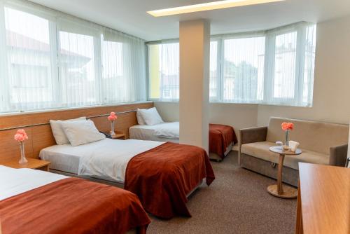 a hotel room with two beds and a chair at The MU City Hotel Trabzon in Trabzon