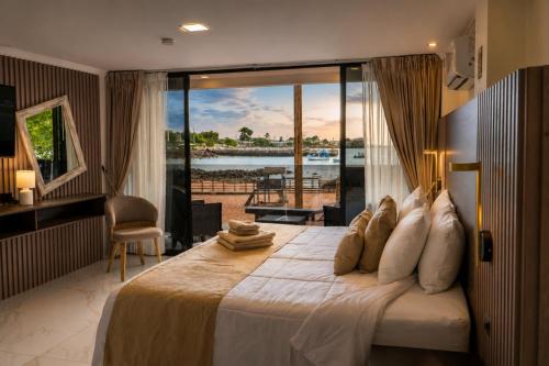 a bedroom with a large bed with a view of the water at Plaza Lobos in Puerto Baquerizo Moreno