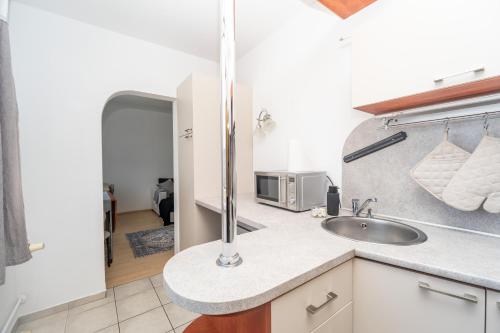 a kitchen with a sink and a microwave at Nesporova Apartment in Košice