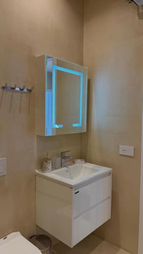 a bathroom with a white sink and a mirror at Green Coast Pearl Suites Apartments Palase in Palasë
