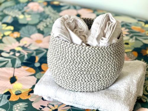 a white basket sitting on top of a pile of towels at Superbe appartement- 10 min Paris- Metro in Maisons-Alfort
