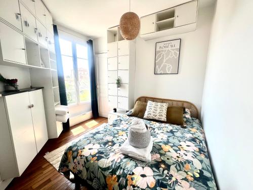 a bedroom with a bed with a floral bedspread at Superbe appartement- 10 min Paris- Metro in Maisons-Alfort