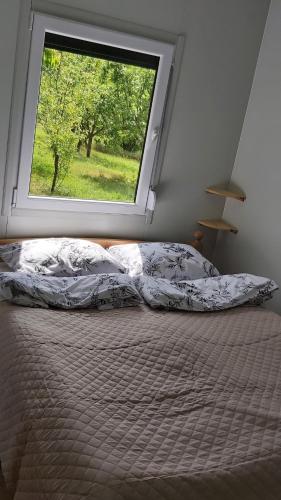 a bed in a bedroom with a large window at Resort-Music Mostar in Potoci