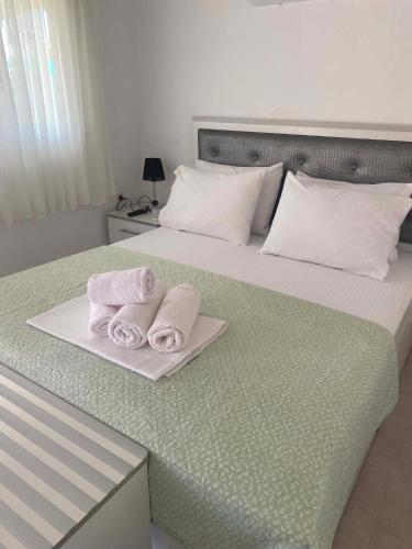 a bed with two towels on a plate on it at Adam House-Castle view in Toroni