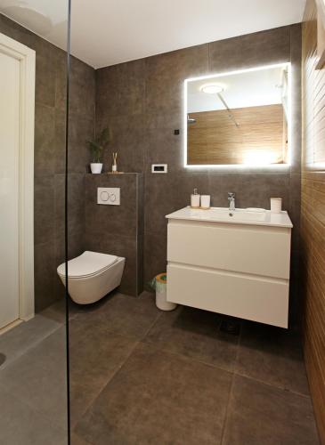 a bathroom with a sink and a toilet and a mirror at Old town Bol apartments in Bol